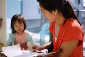 Asian Chinese Mother and Daughter reading books in the library
