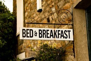 Vintage,Bed,&,Breakfast,Sign,Attached,To,Rustic,Brick,Building