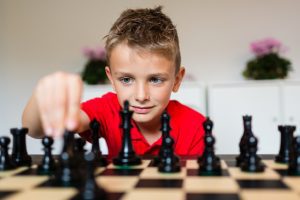 Young,White,Child,Playing,A,Game,Of,Chess,On,Large